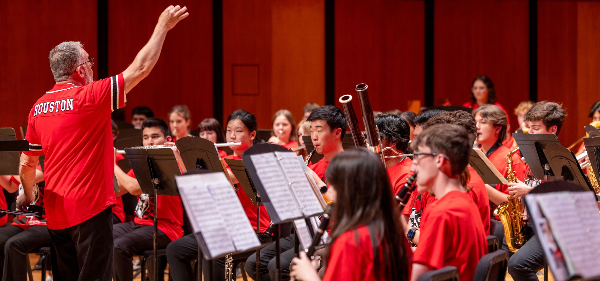 David Bertman in a UH shirt conducting the UH High School Wind Ensemble