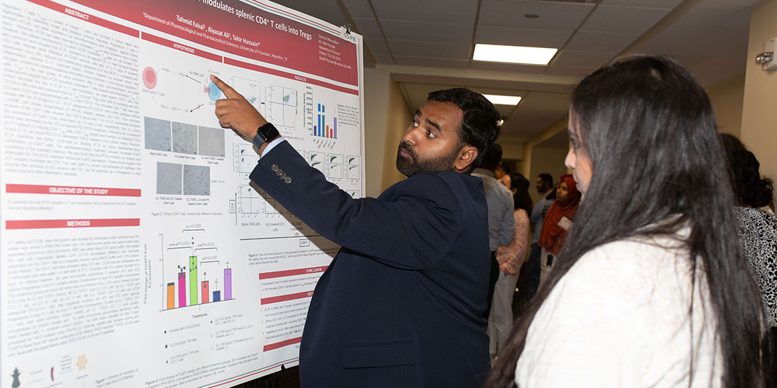 Graduate students presents poster.