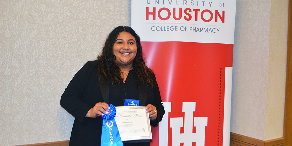 Competition winner smiling with her certificate and ribbon.