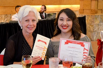 Two women sitting side by side at a banquet table