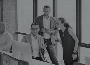 Grey-tinted image of three people looking at a computer screen