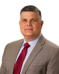 Portrait of a man wearing a grey suit and red tie