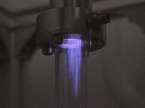 Close up of a purple microwave plasma inside a clear tube.