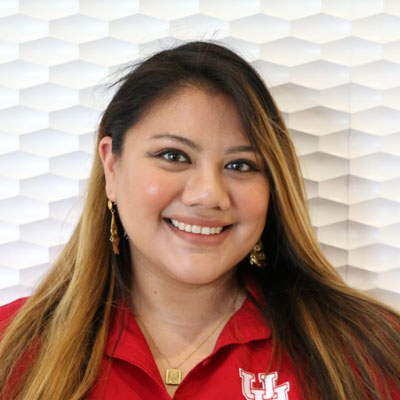 Portrait of a Asian woman smiling with dark mid-back length hair wearing a red button-up shirt