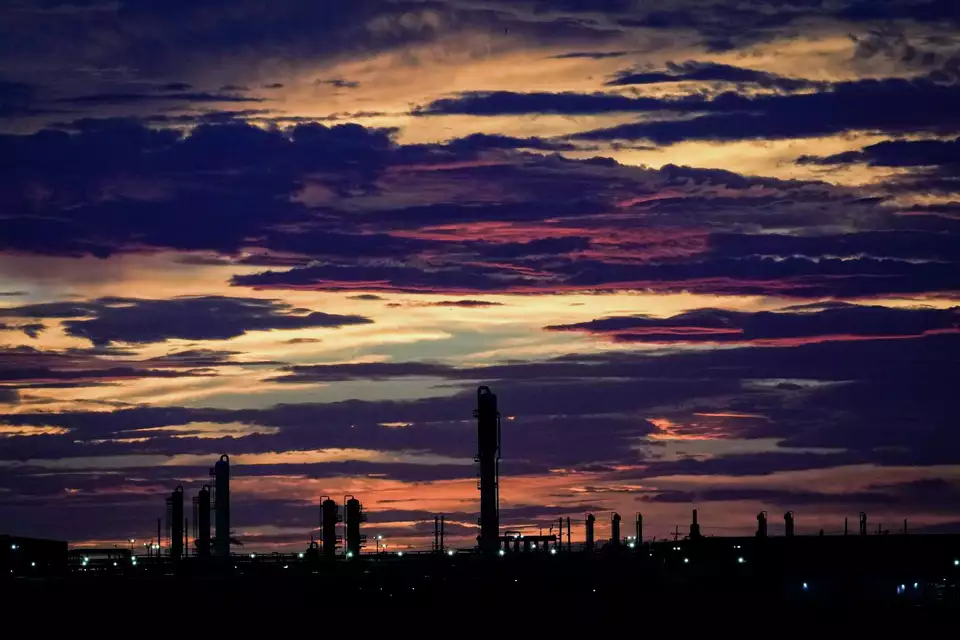 Sun setting over refinery